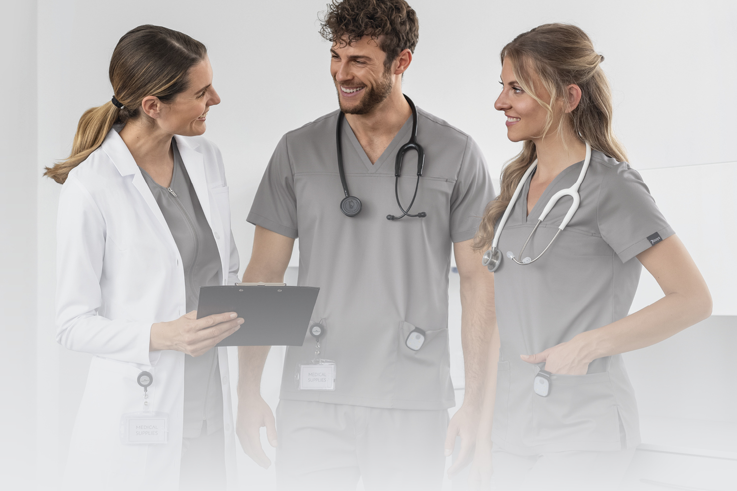 Kolme henkilöä 7days-työvaatteissa katsovat toisiaan